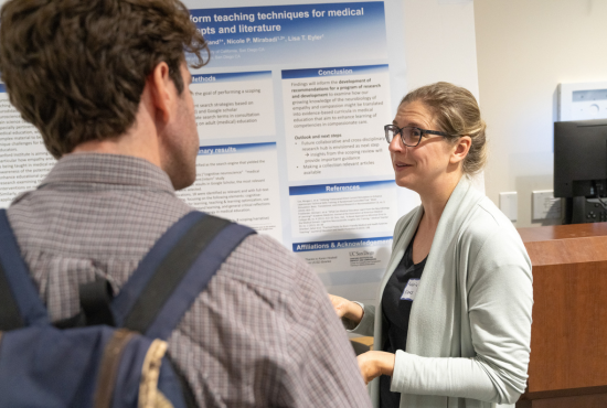 Photo of researcher presenting a poster to a man